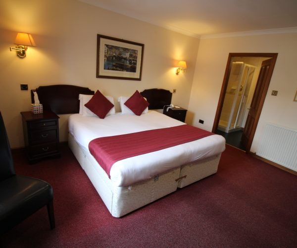A comfortable bed in a hotel room, conveniently located near the popular Elgin restaurant and bar.