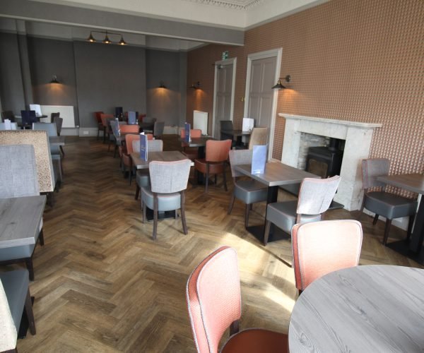 A dining room with tables and chairs, perfect for breakfast or dinner.