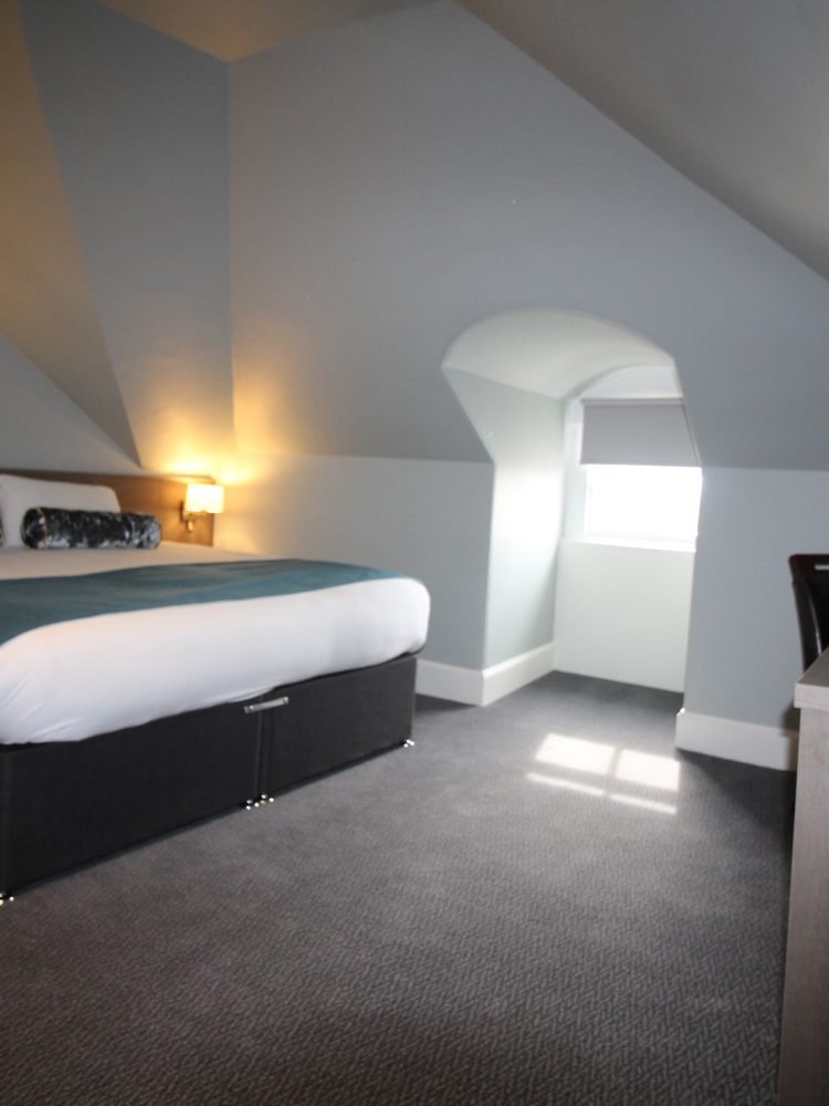 A bed in a room with an attic.